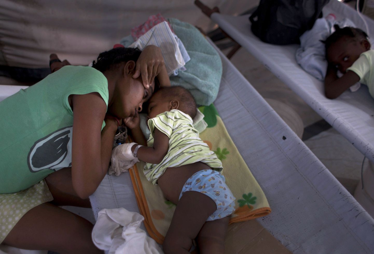 Haiti naine oma koolerat põdeva poja kõrval Port-au-Prince'i kliinikus.