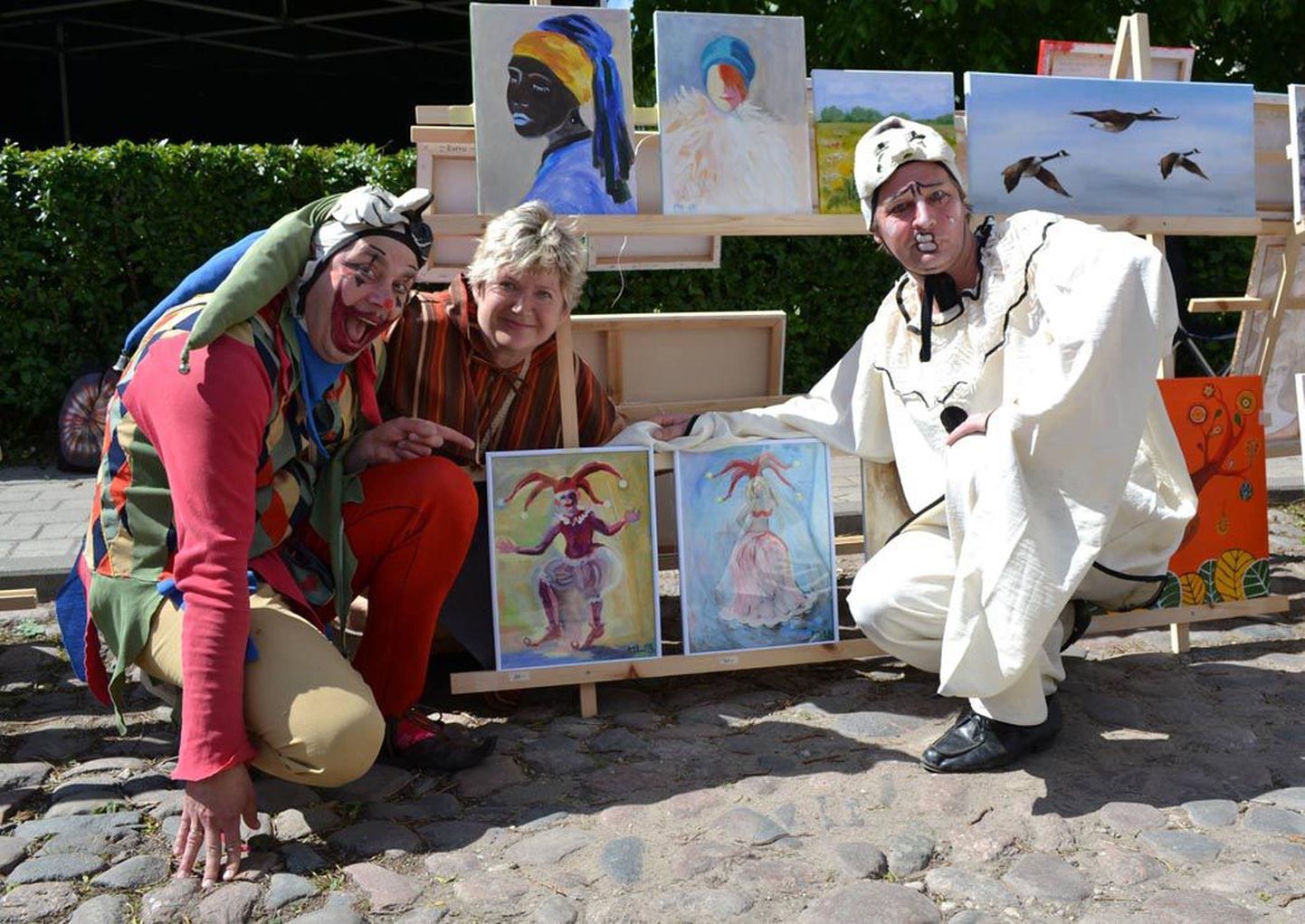 Kunstiklubilane Marju Lorentson on oma maaliväljapaneku ees koos Viljandi hansapäevade maskotiklounidega.