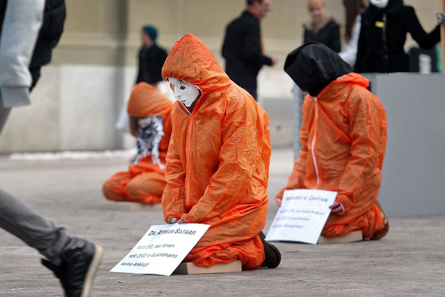 Участники демонстрации в костюмах заключенных выступают против пыток в тюрьме Гуантанамо.