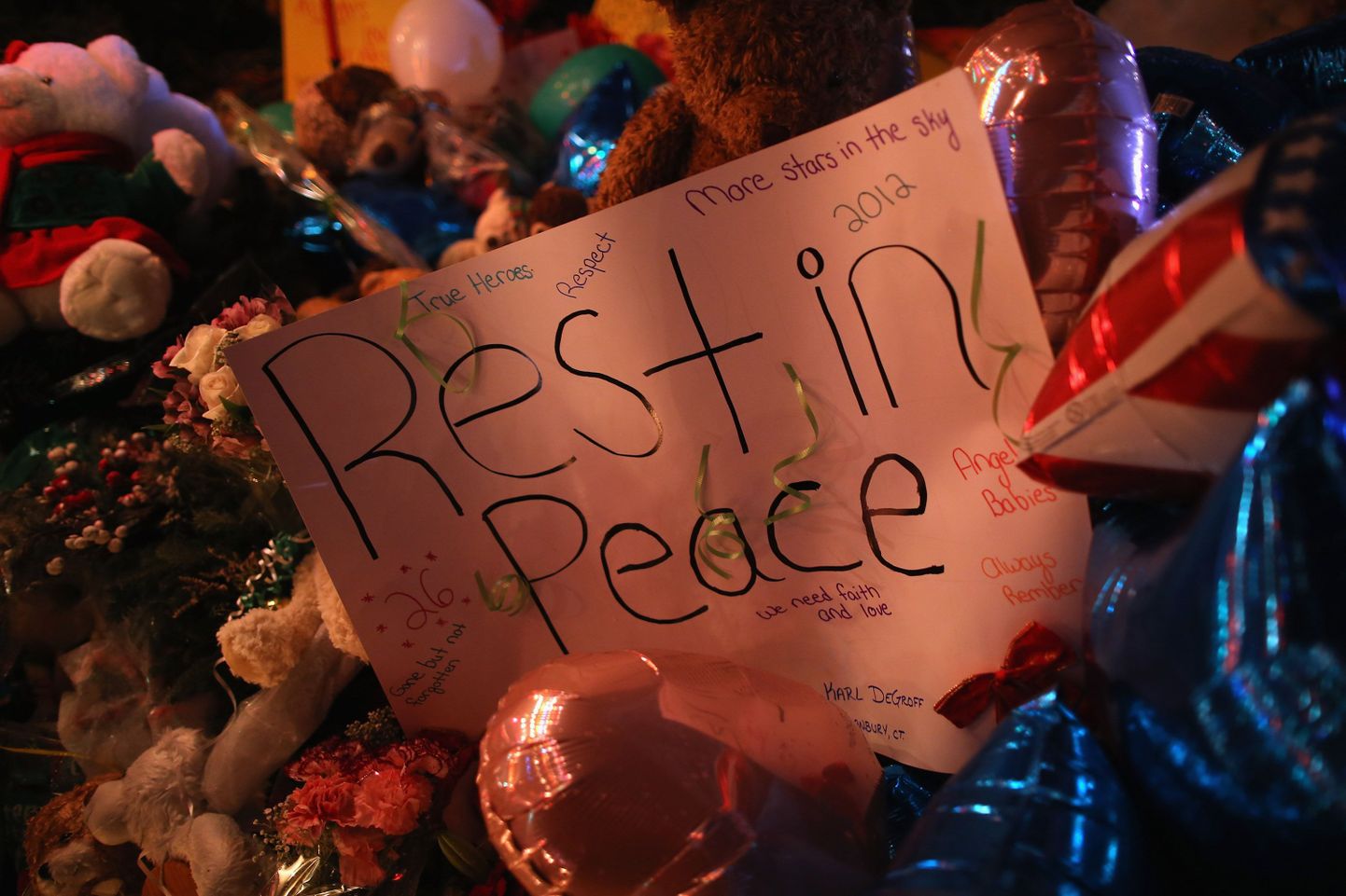 Newtowni koolitulistamise ohvrite mälestuseks asetatud kiri, lilled ja küünlad
