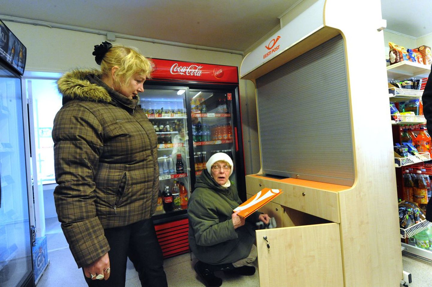 Viinistu kaupluse juhataja Reet Rohumets (vasakul) ja postitöötaja Mare Maaniit uurivad uut postikappi, mis nüüd poes on koha leidnud.