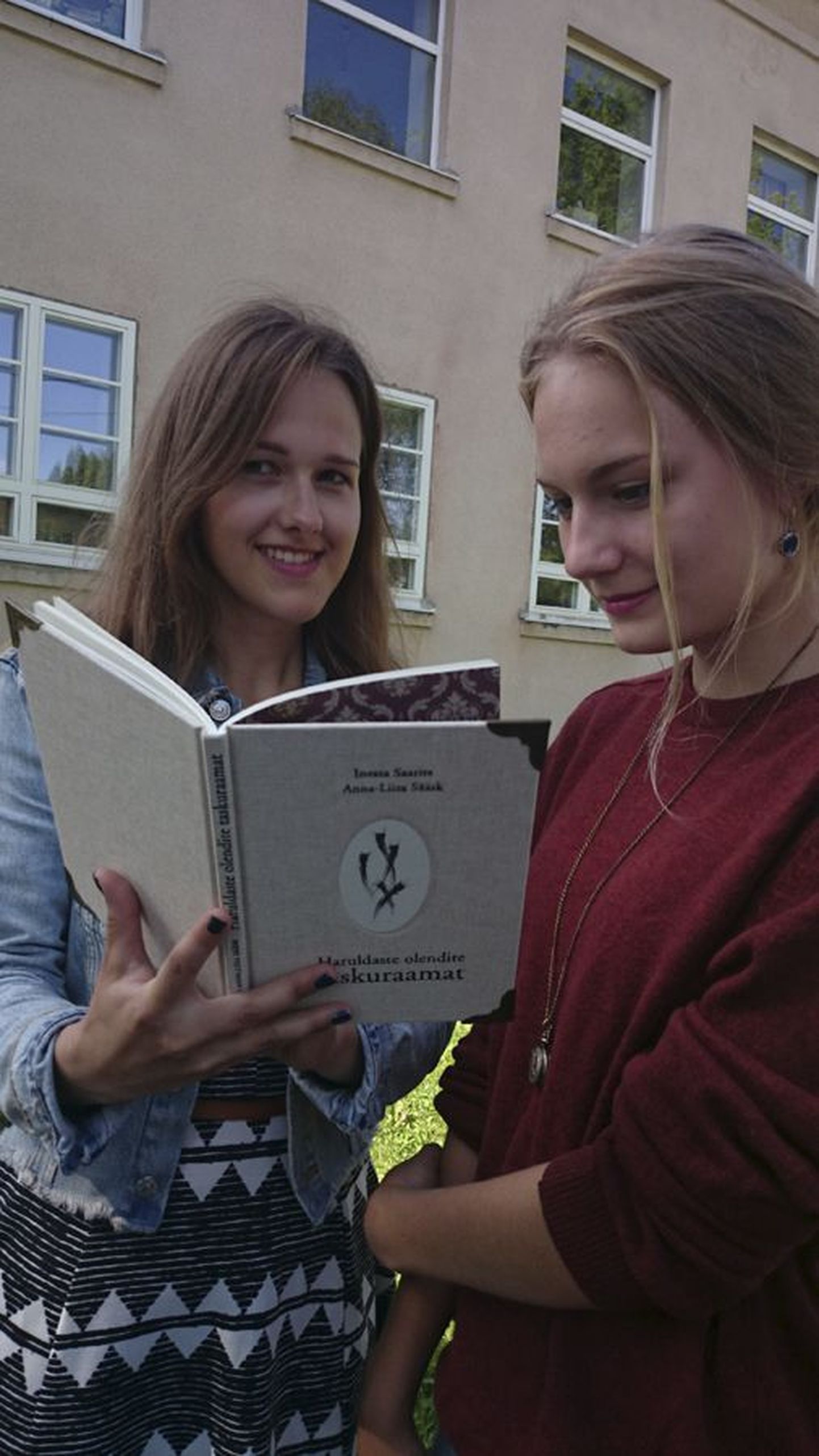 Inessa Saarits ja Anna-Liisa Sääsk hoiavad käes oma esimest raamatut, mis sai pealkirjaks «Haruldaste olendite taskuraamat». Kaanel on Kõrrepead, keda võib täiesti tõsimeeli pidada raamatu idee andjateks.