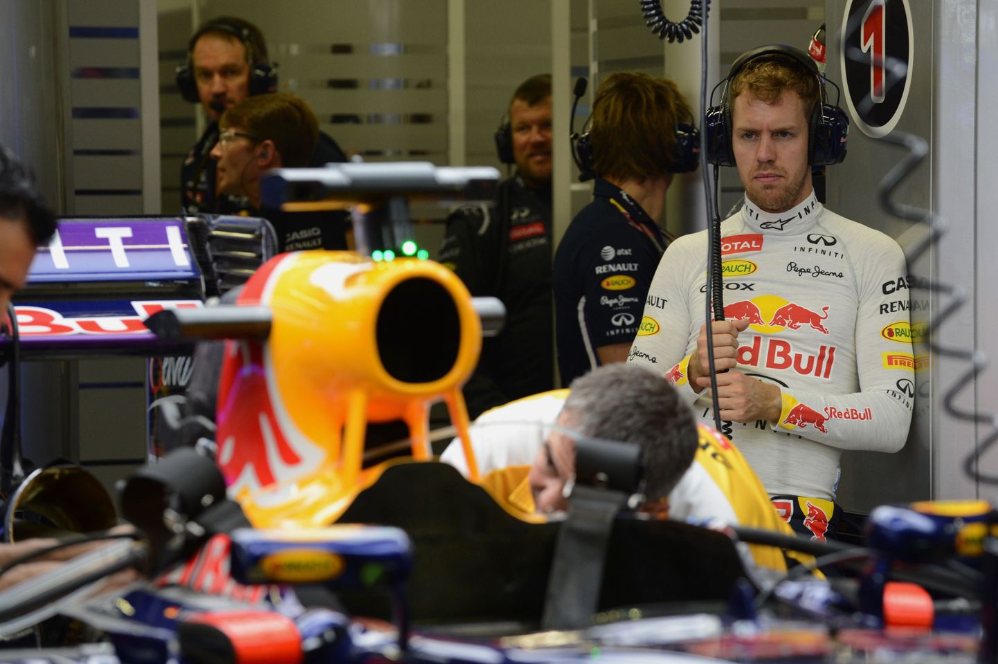 Morn Sebastian Vettel (taustal) jälgib, kuidas meeskond remondib tema auto jõuallikat.