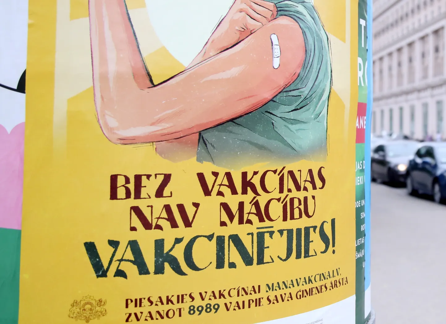 Vakcinācijas pret Covid-19 vides plakāts uz reklāmstaba.