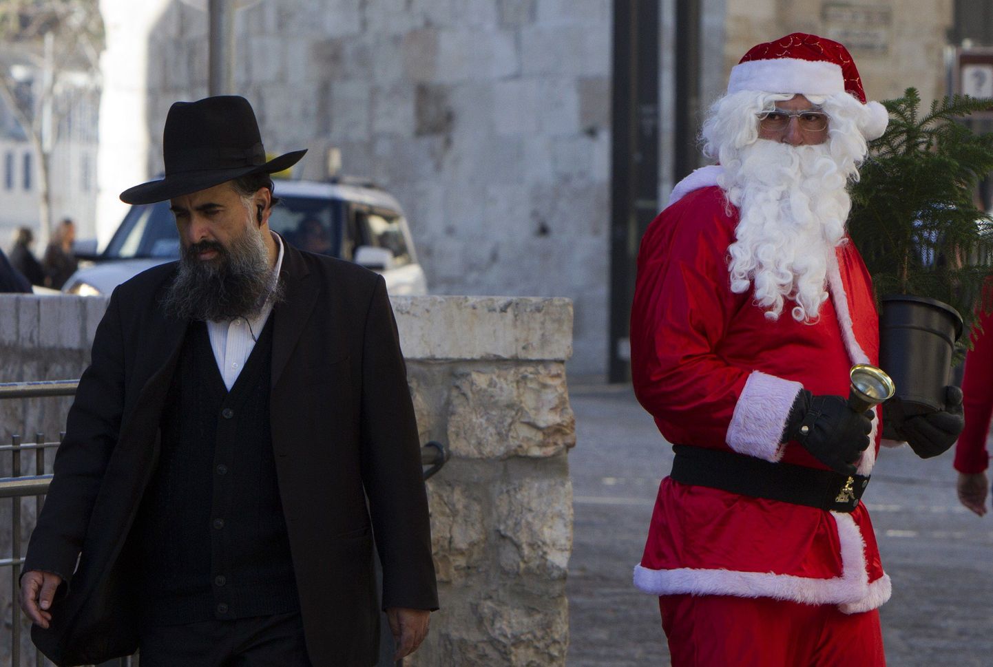 Ultraortodoksist juut eile jõuluvanaks riietunud palestiina mehest Jeruusalemmas möödumas.