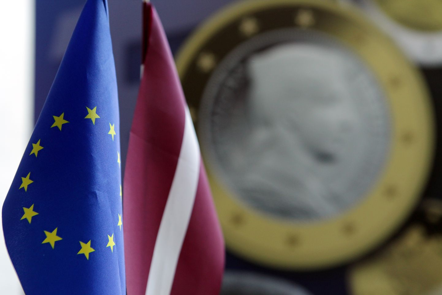 Eiro monētas un Eiropas Savienības (ES) un Latvijas valsts karodziņi pasākumā ES mājā, kura laikā tiks vērota tiešraide no Ekonomikas un finanšu ministru padomes sanāksmes, kurā tiks pieņemts galīgais lēmums par Latvijas uzņemšanu eirozonā. (Publicitātes foto)