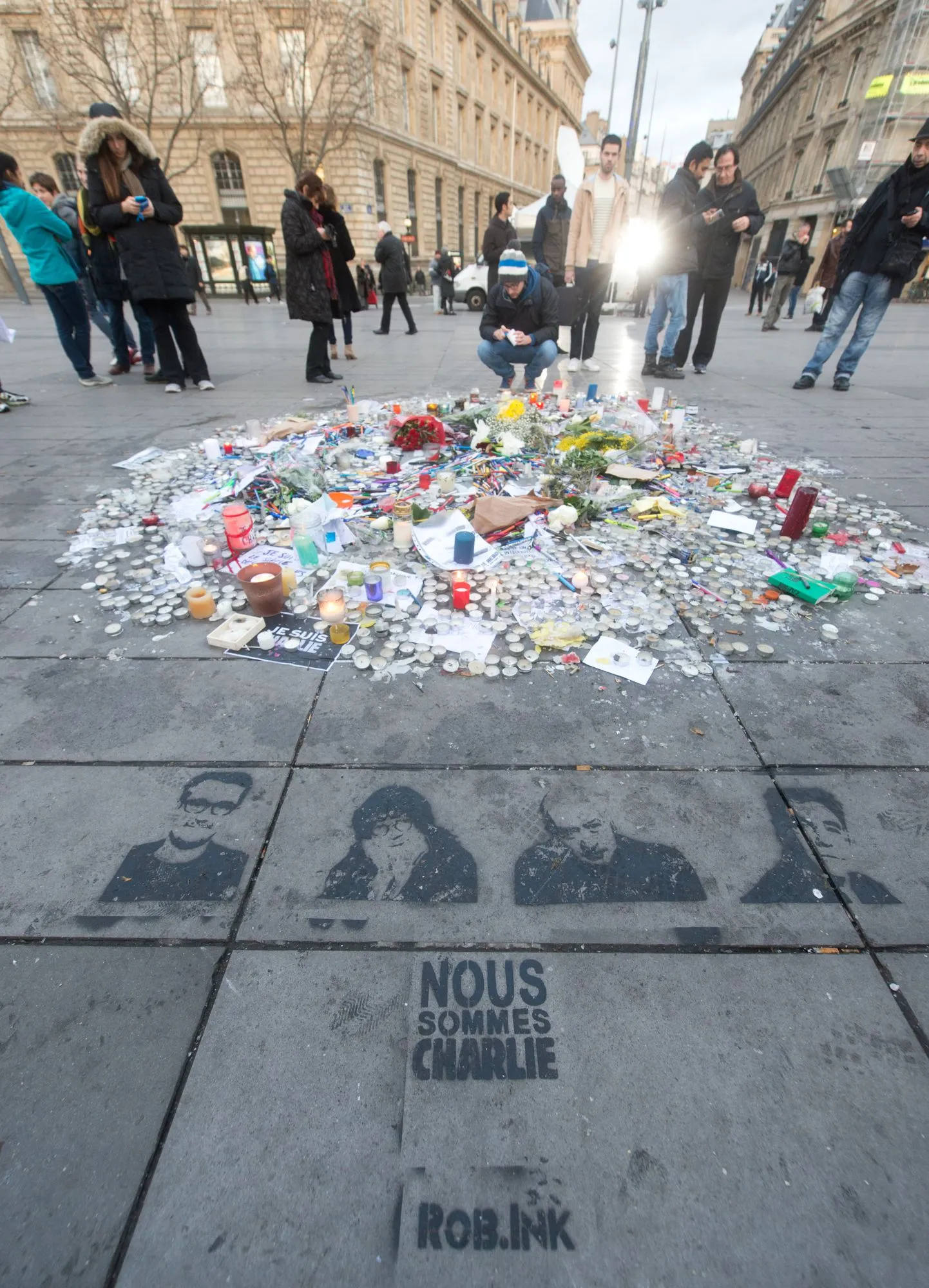 Lilled, küünlad ja kirjutusvahendid satiiriväljaande Charlie Hebdo ajakirjanike ja karikaturistide mälestuseks Vabariigi väljakul Pariisis.