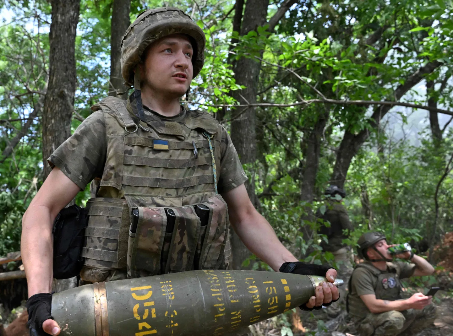 Ukraina sõdur kannab 155 mm kaliibriga mürsku Donetski oblastis paiknevate Vene positsioonide lähedal, 23. juunil 2023. a.