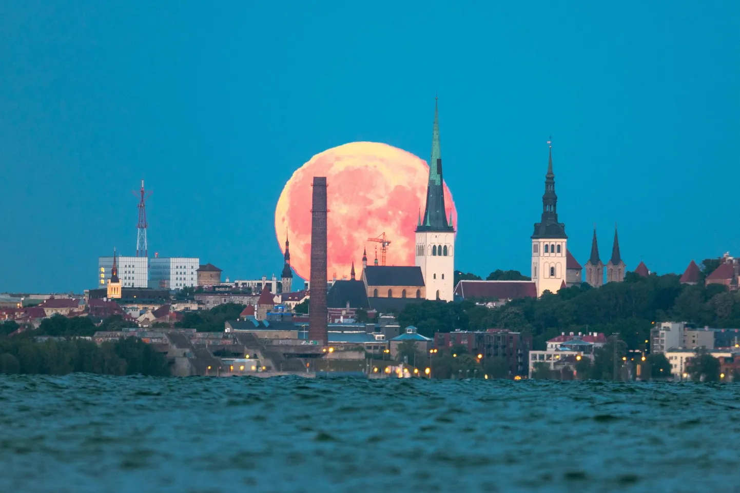 Loojuv täiskuu, pildistatud tänavu 5. juunil kell 3.43. Foto on tehtud Pringi rannas Viimsis ja pildil olevate kirikutornideni on sealt 9,5 km. Sellise pildi saab teha vaid tänu võimsale suumobjektiivile ja asjaolule, et kirikutornide nurkkaugus on Pringi rannalt vaadatult enam-vähem sama kui Kuu läbimõõtki.