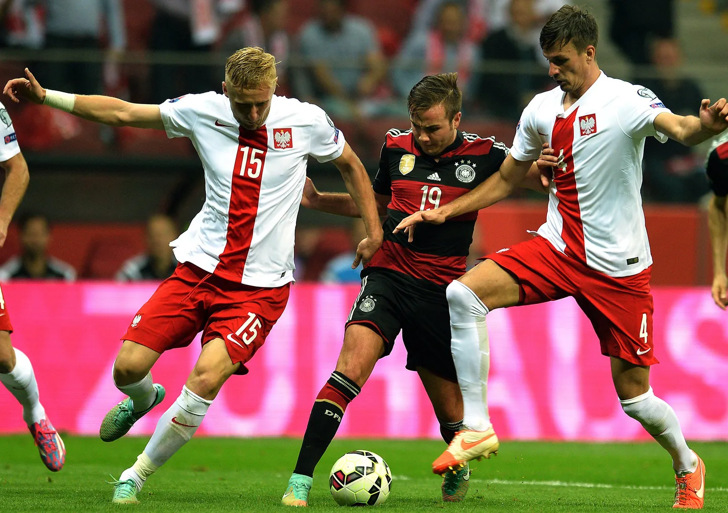 Sakslaste ründaja Mario Götze (keskel) on jäänud Poola kaitsjate Kamil Gliki (vasakul) ja Lukasz Szukala haardesse.