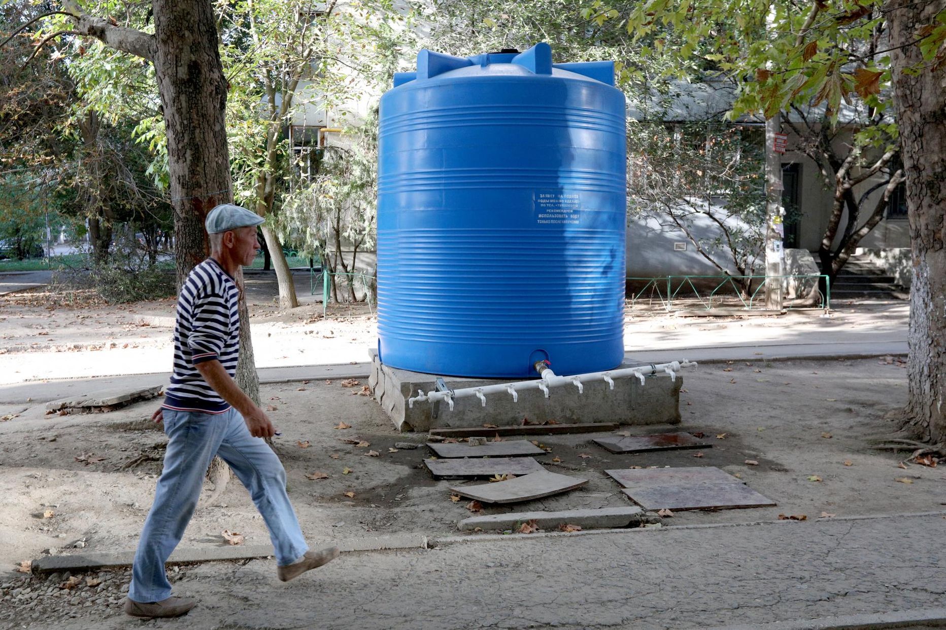 Mees jalutab mööda Krimmis Simferopolis kortermaja ette paigaldatud veekonteinerist. 