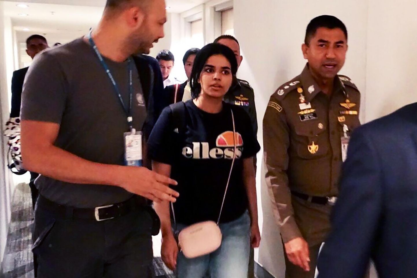 Sauditar Rahaf Mohammed al-Qunun (keskel) eile Tai immigratsiooniametnike saatel Bangkoki Suvarnabhumi lennujaama hotelli koridoris.