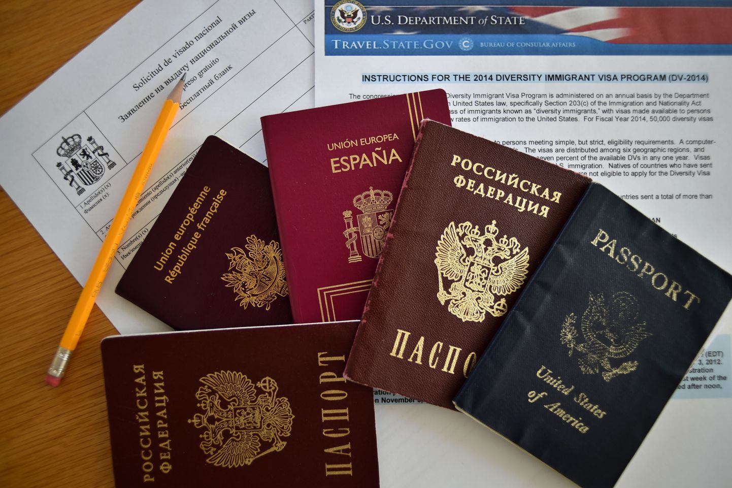 TO GO WITH AFP STORY 
A picture taken  in Moscow on July 31, 2014, shows Russian, US, Spanish an British passports laying together with visa application forms. A new law goes into effect this week requiring Russians to declare to the authorities if they have the citizenship of another country, a measure that has sparked angst in a state with a long history of repression.  AFP PHOTO