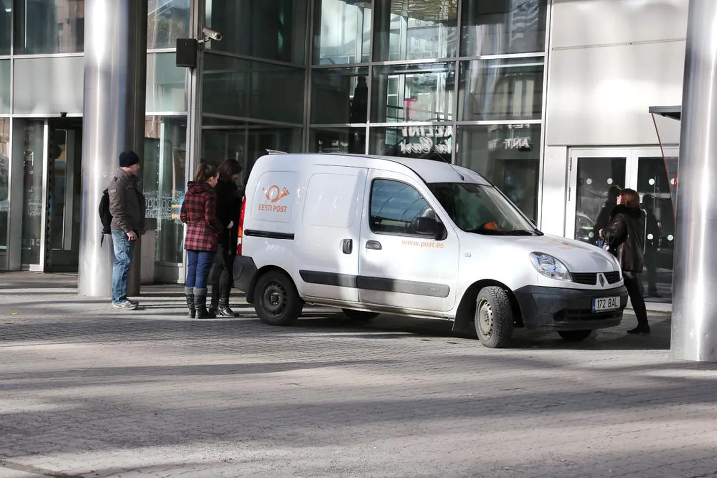 Kuller väljastab Viru keskuse ees seisvast postiautost pakke, mis enam automaatidesse ei mahtunud.