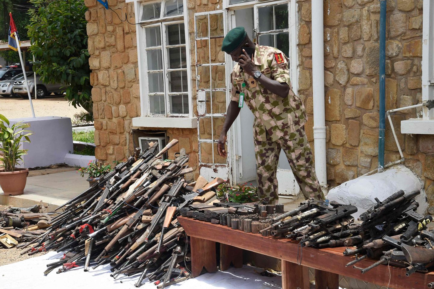 A Nigerian soldier is seen on April 21, 2022 amid small arms and light weapons recovered from bandits during Operation Safe Haven and during the military mop up in Jos and surrounding areas in Plateau State in northcentral Nigeria. - The Nigerian military under the platform of Operation Safe Haven has handed over 517 small arms and light weapons recovered recently from bandits to the National Centre for the Control of Small Arms and Light Weapons following successes in checking bloodletting and insecurity occasioned by the proliferation of illicit arms in circulation. (Photo by PIUS UTOMI EKPEI / AFP)