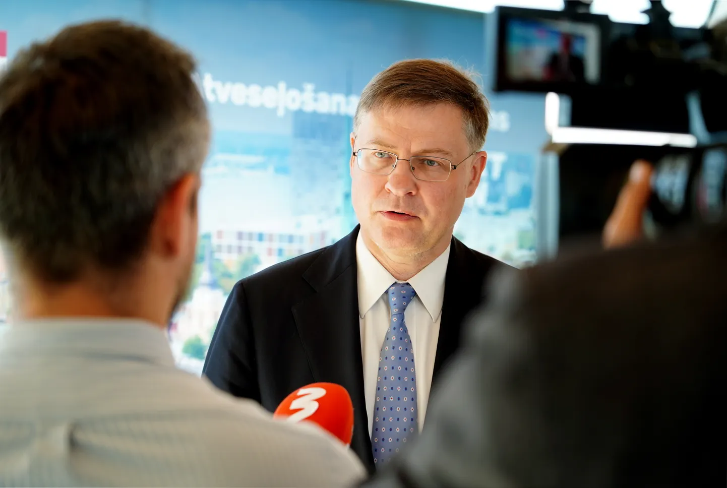 Eiropas Komisijas priekšsēdētājas izpildvietnieks Valdis Dombrovskis atbild uz žurnālistu jautājumiem Atveseļošanas fonda plāna otrā maksājuma nodošanas pasākumā Latvijas Nacionālās bibliotēkas korē.