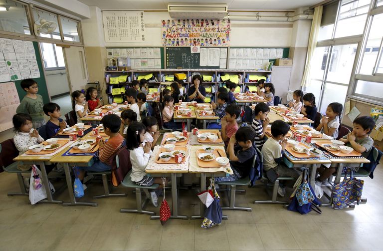 Esimese klassi lapsed koos õpetaja Teruko Takakusakiga lõuna ajal Takinogawa Algkoolis Tokyos, Jaapanis. 
Foto: REUTERS/Toru Hanai