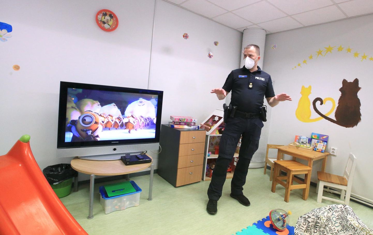 Оперативный глава Лыунаской префектуры Оттомар Вирк показывает игрушки и телевизоры, привезенные в центр для беженцев, – все из домов сотрудников полиции. Они же разрисовали стены арестного дома.