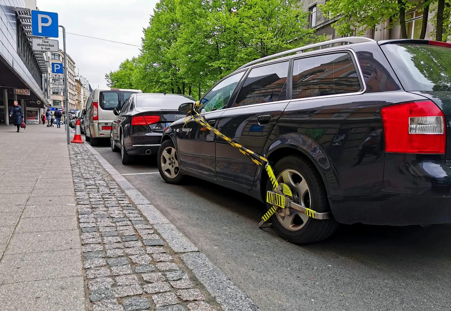 Automašīna stāvvietā ar nobloķētu riteni