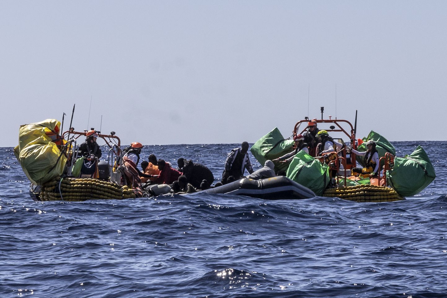 SOS Méditerranée humanitaarabilaeva Ocean Viking päästetöötajad aitamas migrante osaliselt tühjaks läinud kummipaadist Vahemere keskosas 13. märtsil 2024. aastal.
