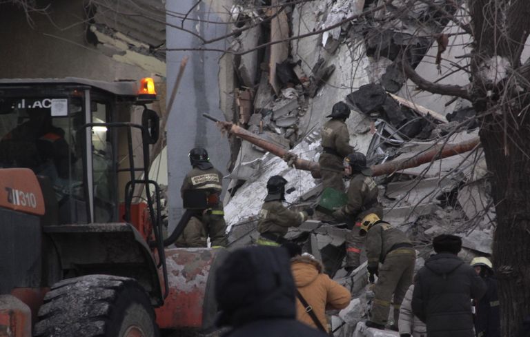 Спасатели работают на развалинах.