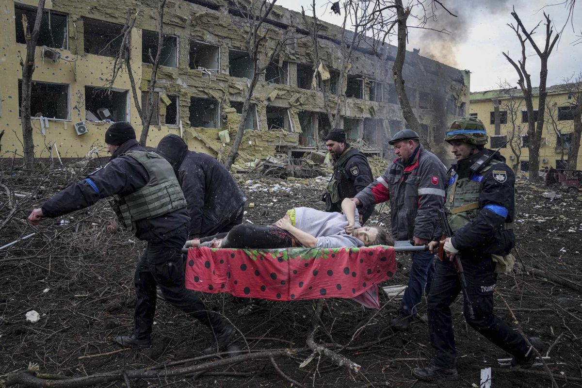 Ukraina päästjad ja vabatahtlikud viivad Vene lennukipommist pihta saanud Mariupoli sünnitusmajast ohutumasse kohta rasedat, 9. märts 2022. Laps sündis surnuna, pool tundi hiljem naine suri. Venemaa on nimetanud neid fotosid võltsinguteks.