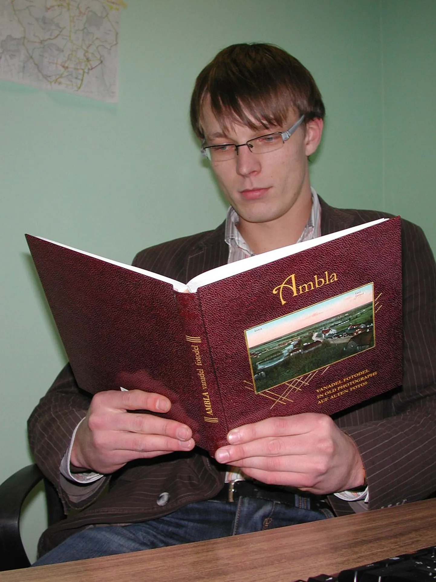 Rait Pihelgas uurib raamatut «Ambla vanadel fotodel», et ennast sealse eluga juba kurssi viia.