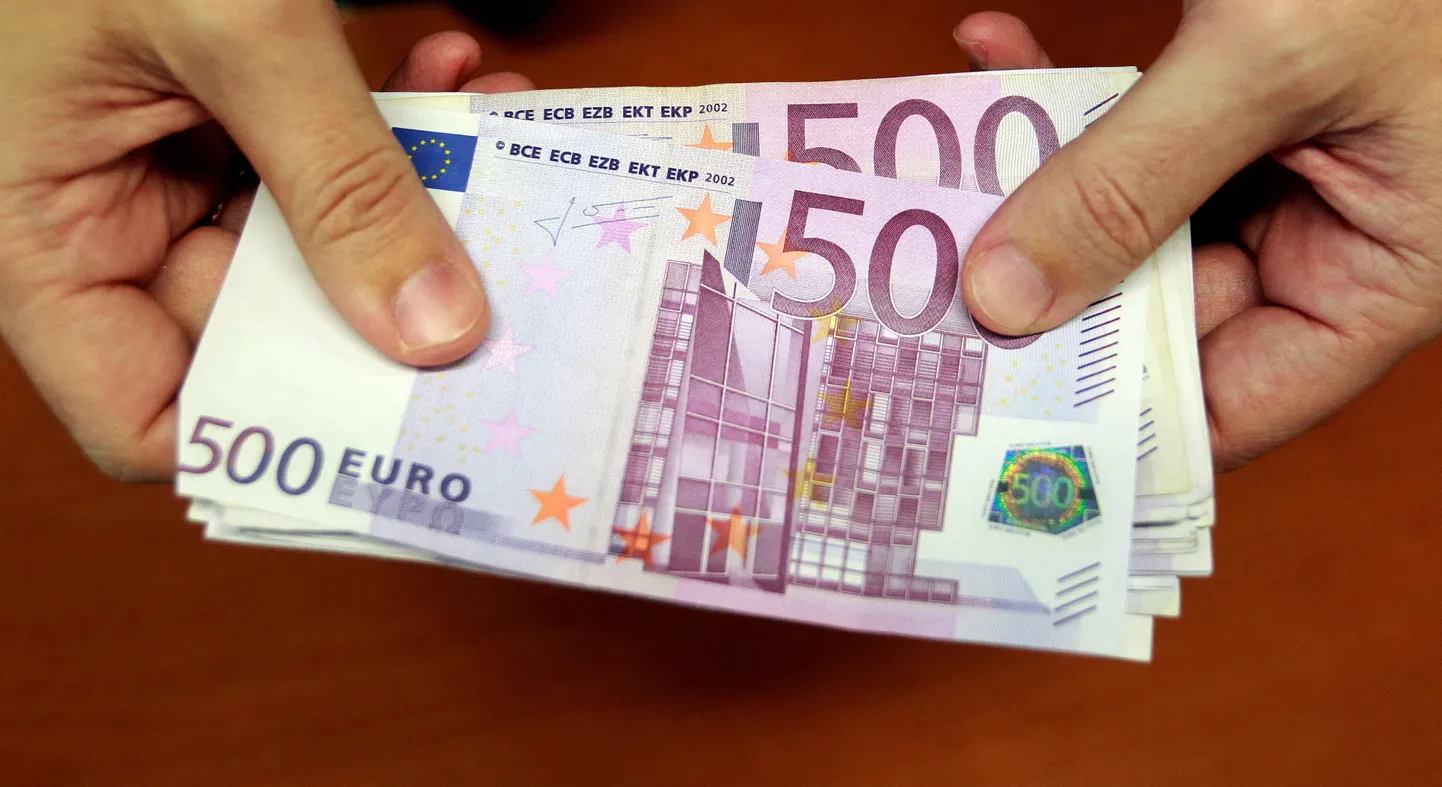 Pangatöötaja hoidmas 500 euroseid kupüüre.