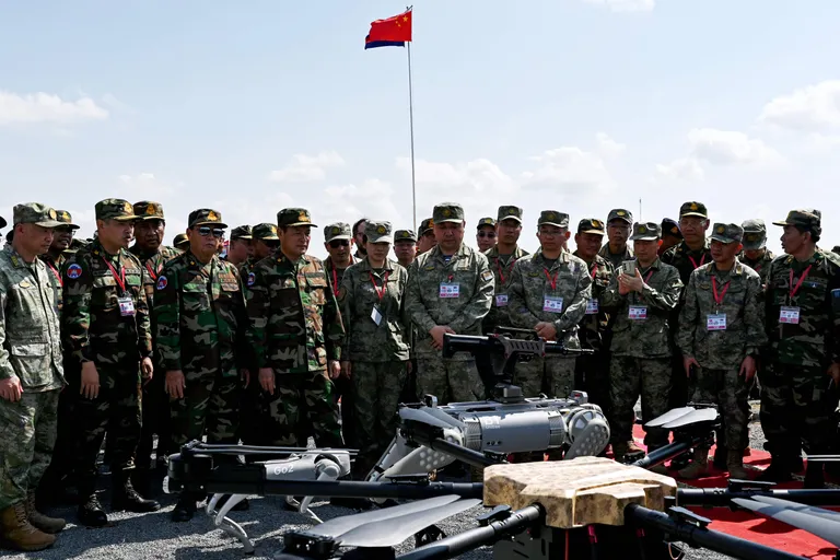 Kambodža ja Hiina relvajõudude kõrged esindajad jälgivad ühisõppustel robotkoera esitlemist. Masinal on seljas automaatrelv.