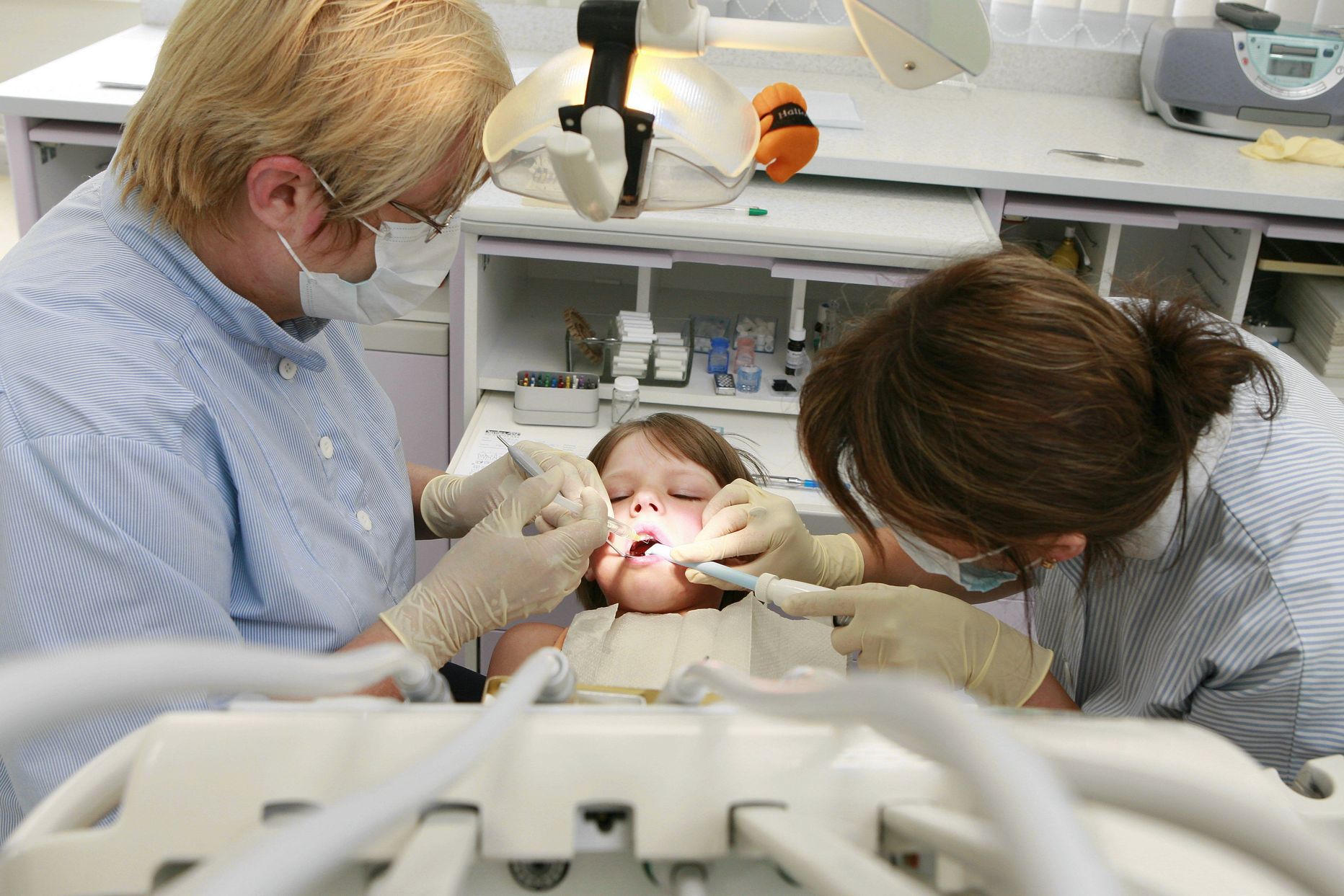 Dentese hambaarst Anu Ilumäe parandab väikese patsiendi murdunud hammast.