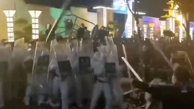 По интернету разошлись видео из Гуанчжоу, на которых полиция в белых защитных костюмах разгоняет людей в масках - предположительно, протестующих у завода по производству айфонов