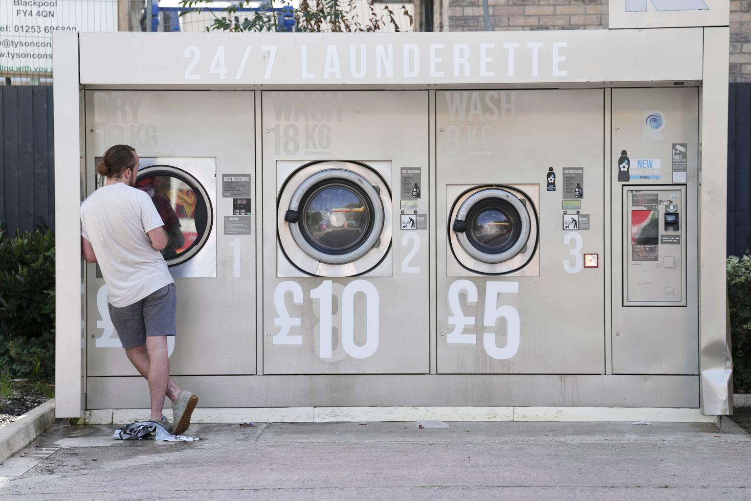 Briti härrasmees 7. septembril 2022 Manchesteri avalikus pesumajas. Masinatele on maalitud värsked hinnad.