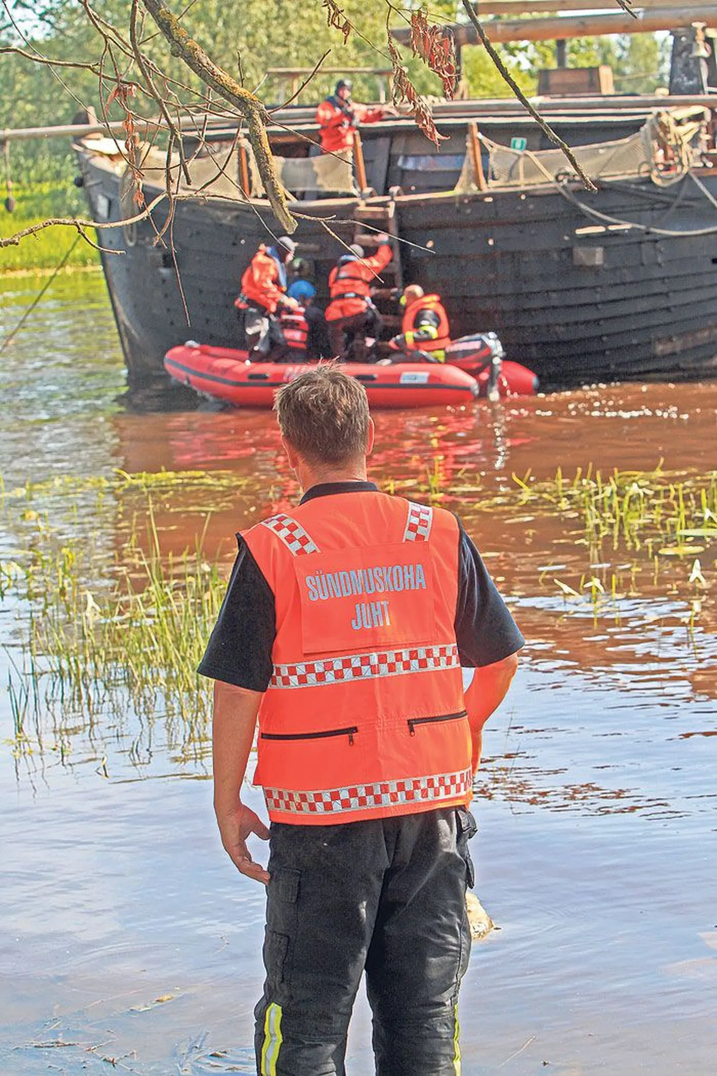 Päästemeeskonna juht jälgib sündmuste kulgu kaldalt.