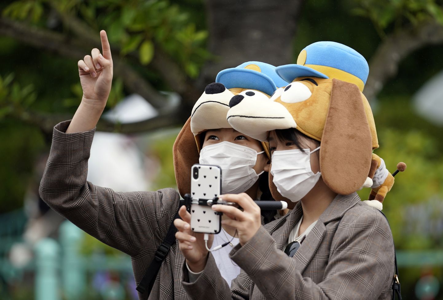 Näomaske kandvad külastajad Tokyo Disneylandis.
