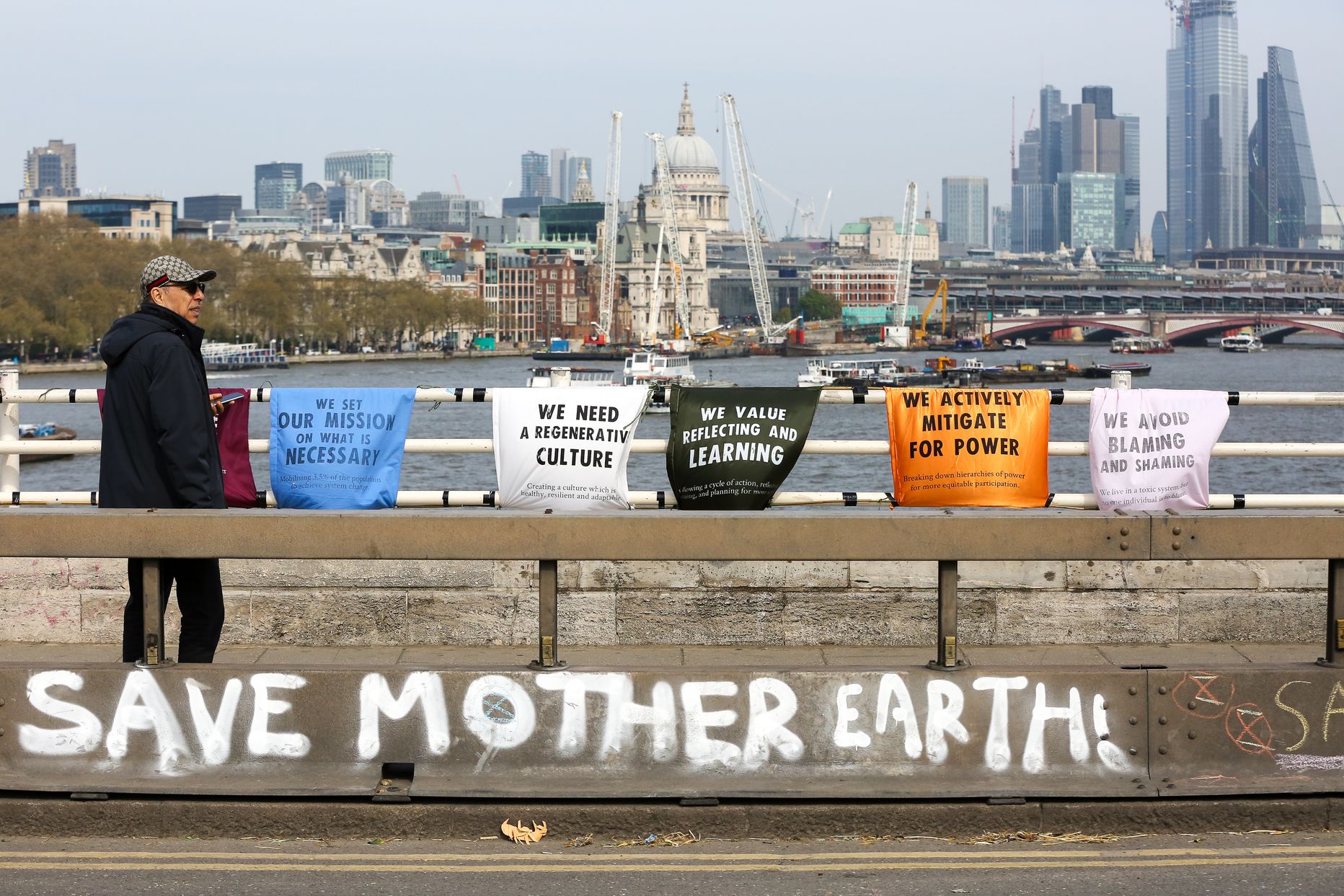 April 18, 2019 - London, UK - A man walks past 'Save Mother Earth' written on the side of the Waterloo Bridge as environmental activists demonstrates on the fourth day of an ongoing climate change protest to demand decisive action from the UK Government on the environmental crisis. (Credit Image: © Dinendra Haria/London News Pictures via ZUMA Wire)