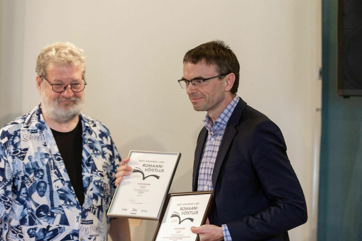 Romaanivõistluse žürii esimees Rein Raud (vasakul) üllatab võiduromaani autorit Sven Mikserit suisa kahe preemiaga.