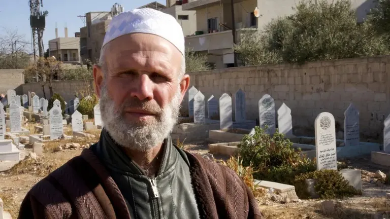 Абдул Кадер аль-Шейха сфотографирован среди надгробных плит на кладбище.