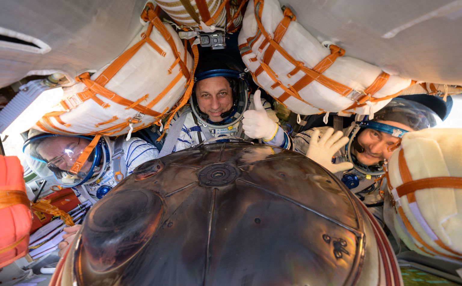 Vene kosmonaudid ja USA astronaut maandumiskapslis.