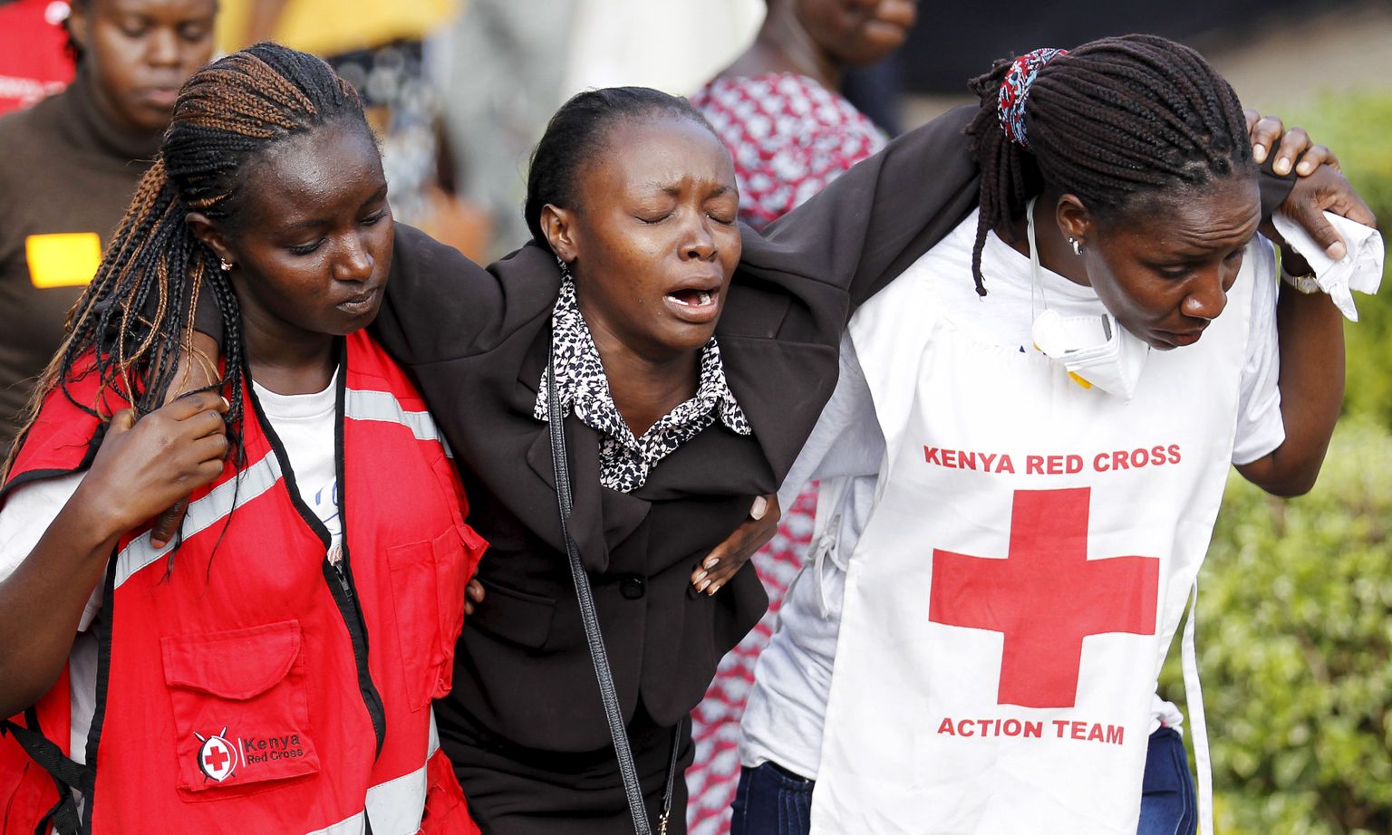 Keenia Punase Risti töötajad toetamas naist, kes käis tapetud tudengite surnukehi hoidvas morgis tuvastamas oma hukkunud lähedase laipa.