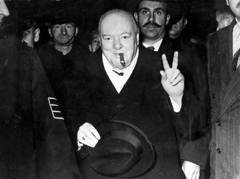 Winston Churchill oma kuulsa sigariga, tegemas käega võidumärgina tuntuks saanud V-tähte. Inglise keeles «victory»