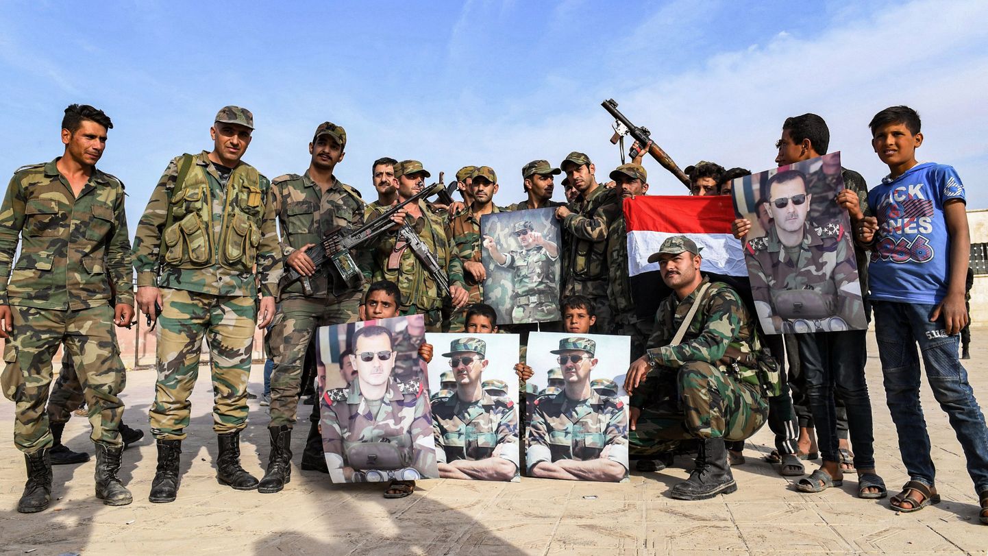 Süüria valitsusväed poseerivad Manbiji lähedal Bashar al-Assadi portreedega.