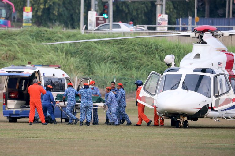 Malaisia sõjaväelased ja parameedikud viimas Nora Quoirini surnukeha helikopterist kiirabiautosse, et ta transportida Serembani haiglasse