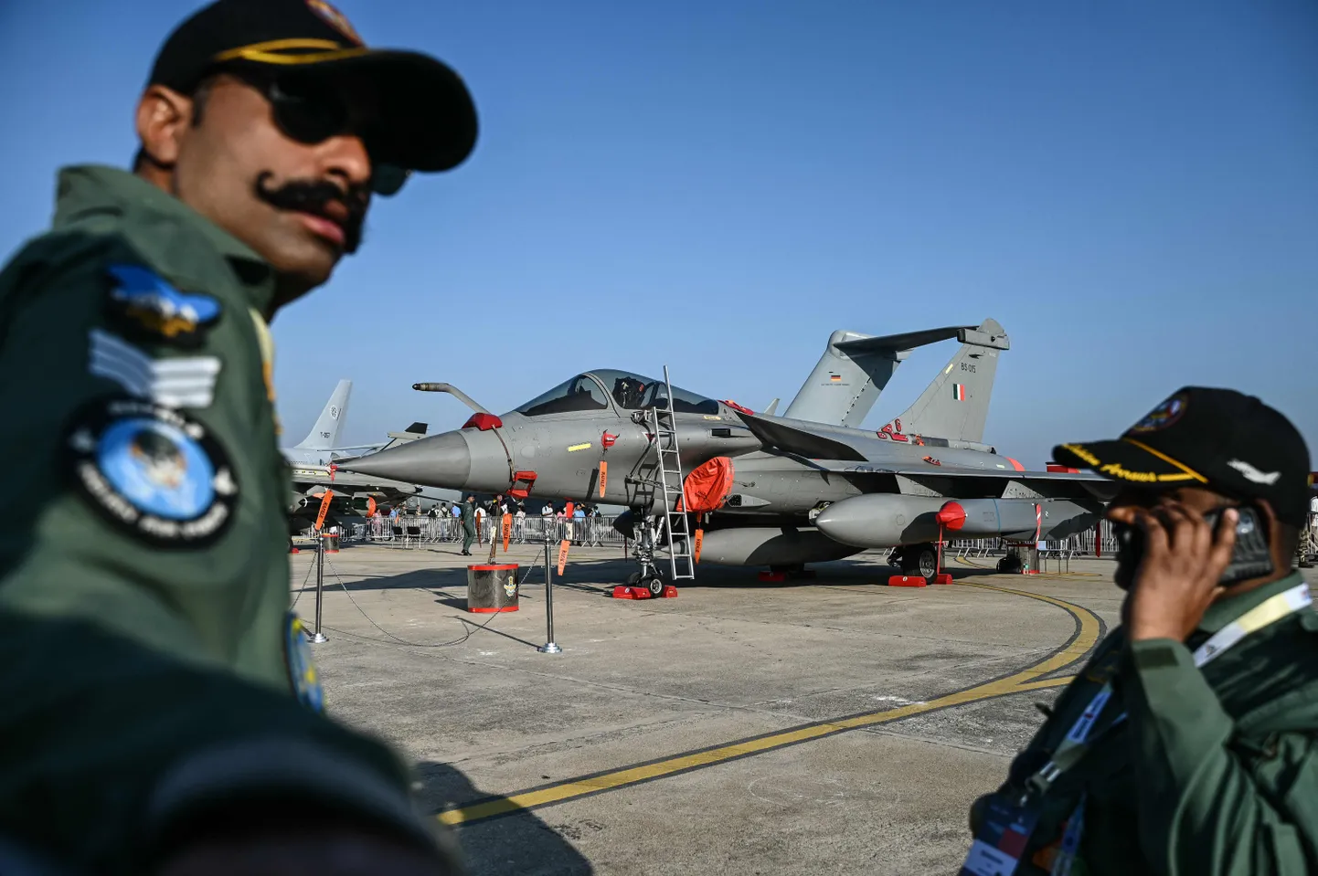 India õhujõudude (IAF) võitlejad seisavad Rafale'i hävituslennuki ees Aero India 2025 näitusel Yelahanka õhujõudude baasis Bengalurus 13. veebruaril 2025. India on allkirjastanud lepingu 26 Rafale'i hävituslennuki ostmiseks Prantsusmaalt, teatas New Delhi kaitseministeerium 28. aprillil 2025, kusjuures mitme miljardi dollari suurune tehing hõlmab nii ühe- kui ka kahekohalisi lennukeid.