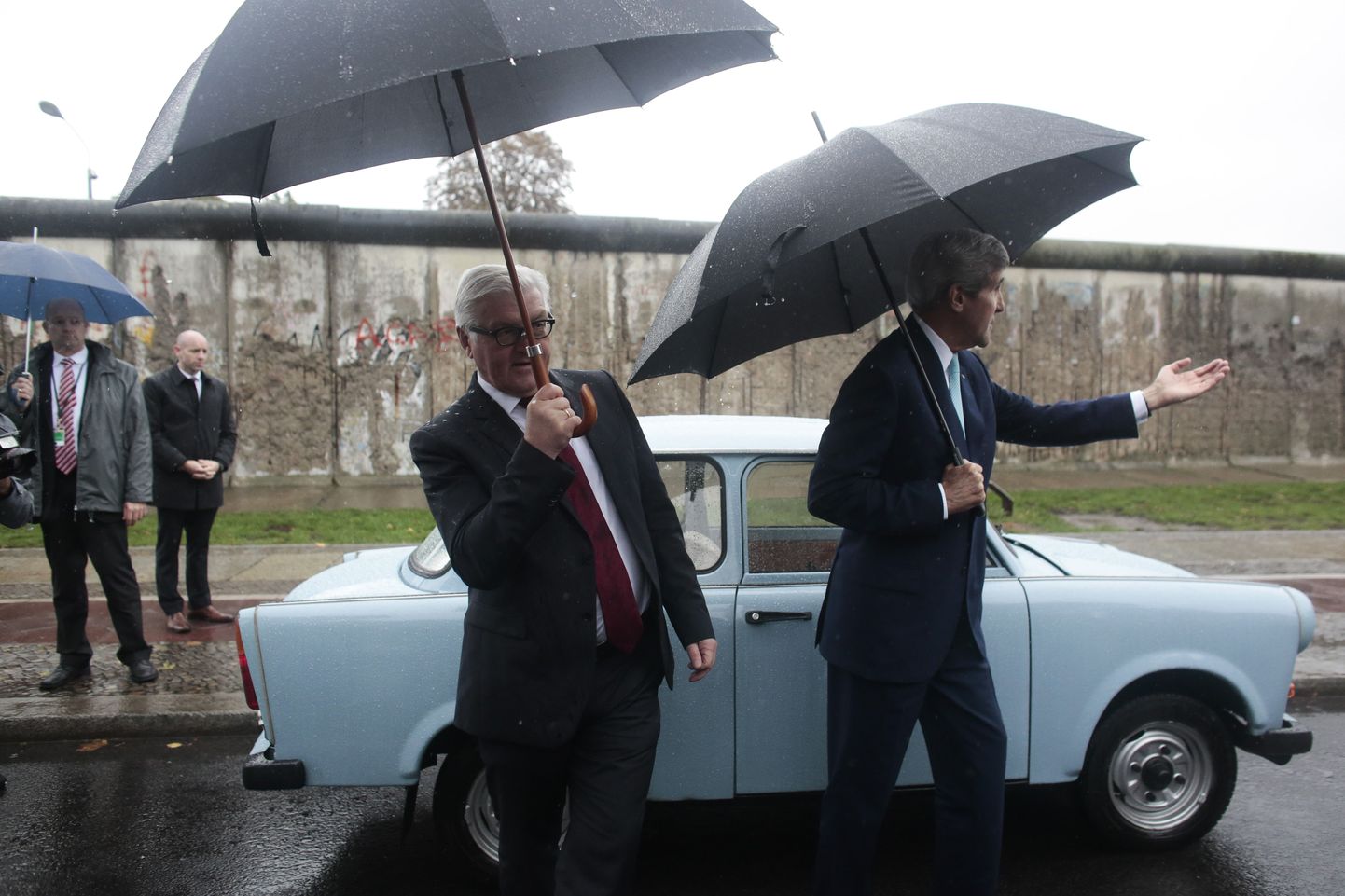 John Kerry (paremal) ja Frank-Walter Steinmeier mööduvad Berliini müüri memoriaali juures Trabant-tüüpi Saksa DV autost.