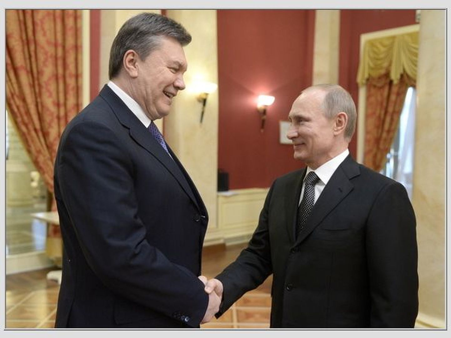 Vladimir Putin (paremal) tervitab kättpidi Viktor Janukovõtšit kõrgete külaliste vastuvõtul Sotši olümpiamängude avapäeval, 2014. aasta 7. veebruaril.