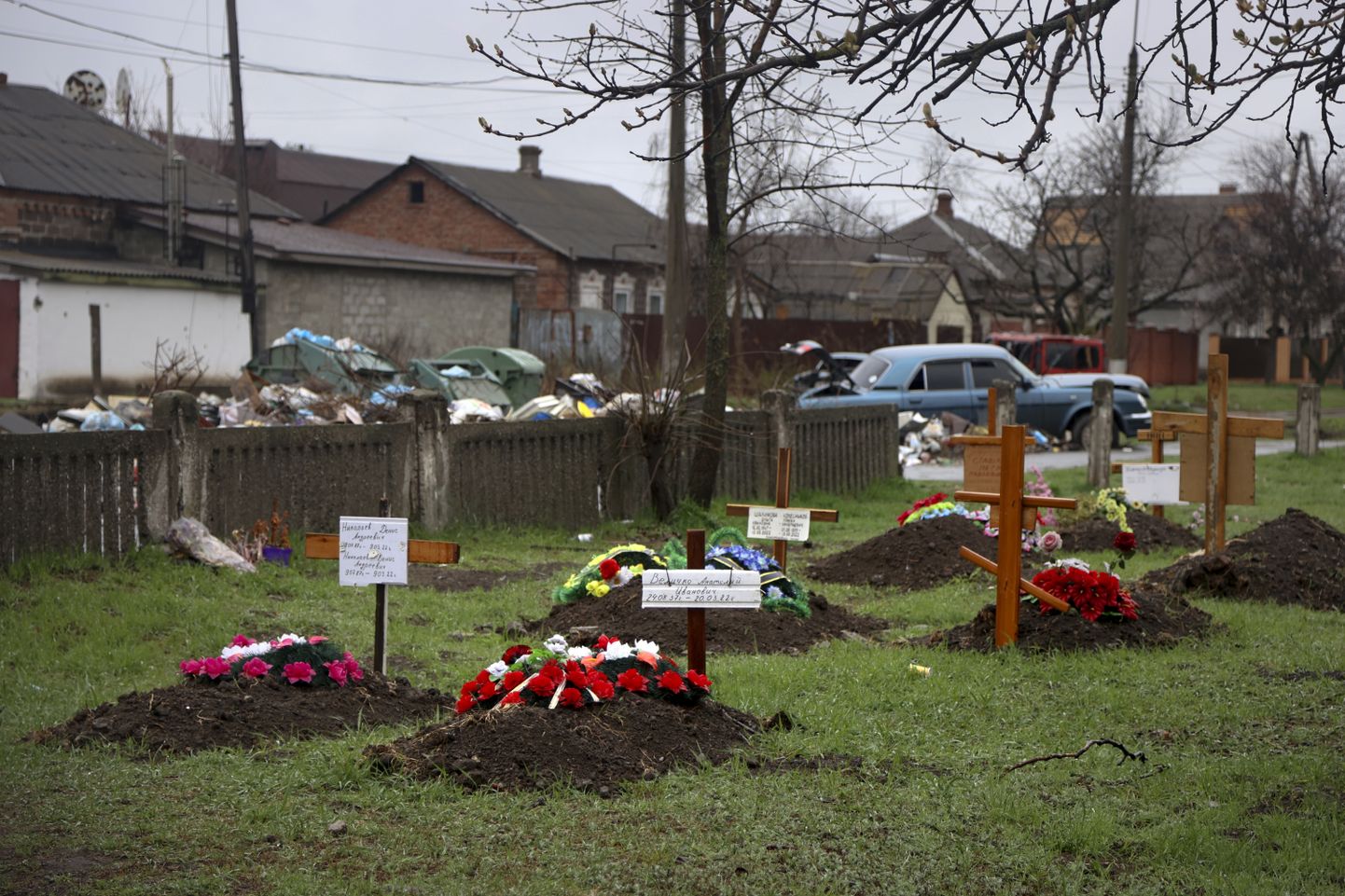 Могилы местных жителей, погибших во время боевых действий с Россией за частными домами в украинском городе Мариуполь, 13 апреля 2022 года.