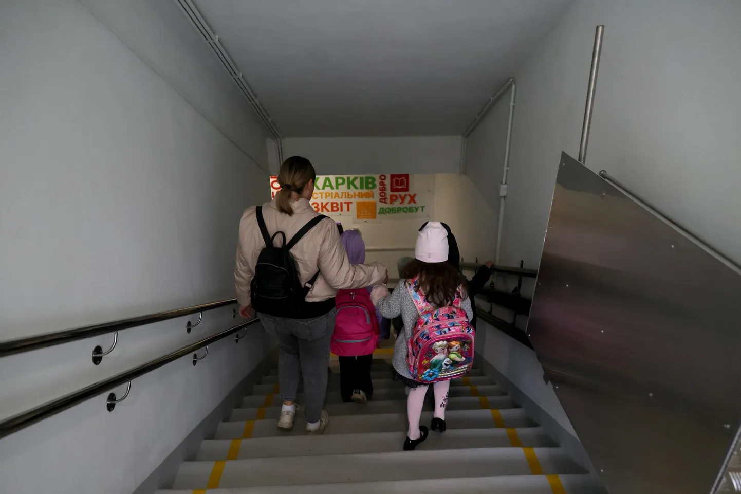 Naine siseneb kahe lapsega Harkivi maa-alusesse kooli. Linnas elab endiselt kohapeal 53 000 kooliealist last. Lisaks elab umbes 50 000 last mujal, kuid veebi teel õpivad nad endiselt Harkivi koolides.
