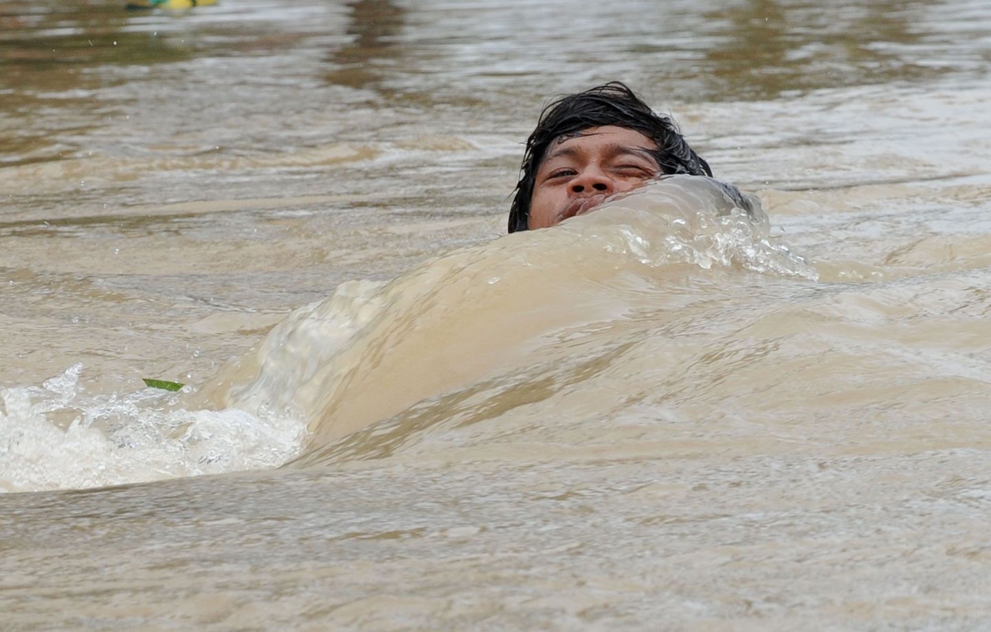 Mees ujumas üleujutuspiirkonna tänaval