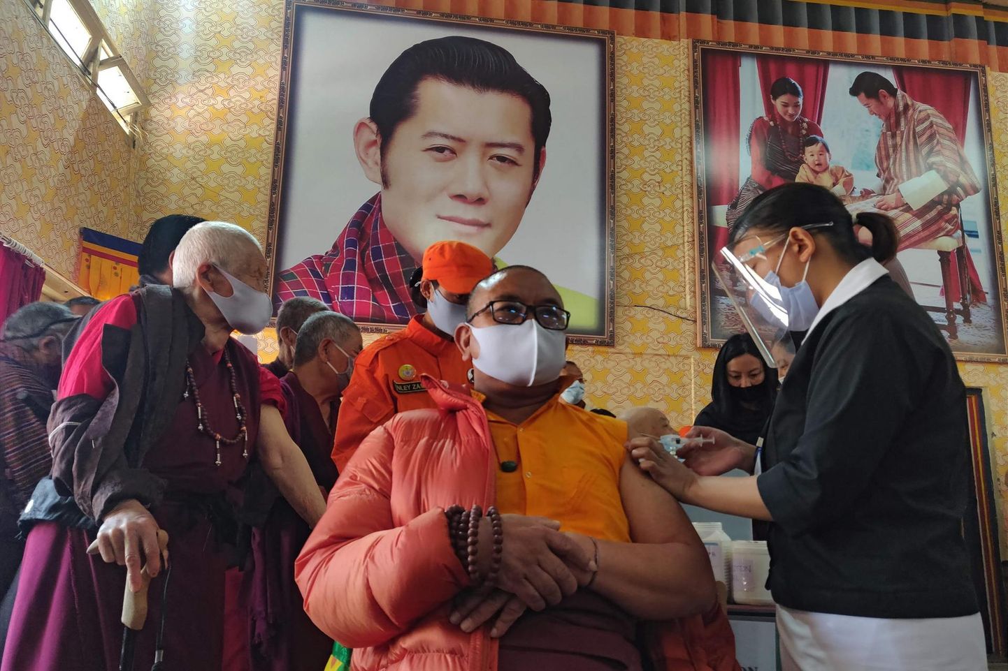 Budistlik munk saab vaktsiini kuningas Jigme Khesar Namgyel Wangchuck portree all 27. märtsil, Bhutani vaktsineerimise esimesel päeval Lungtenzampa keskkoolis Thimphu linnas. 