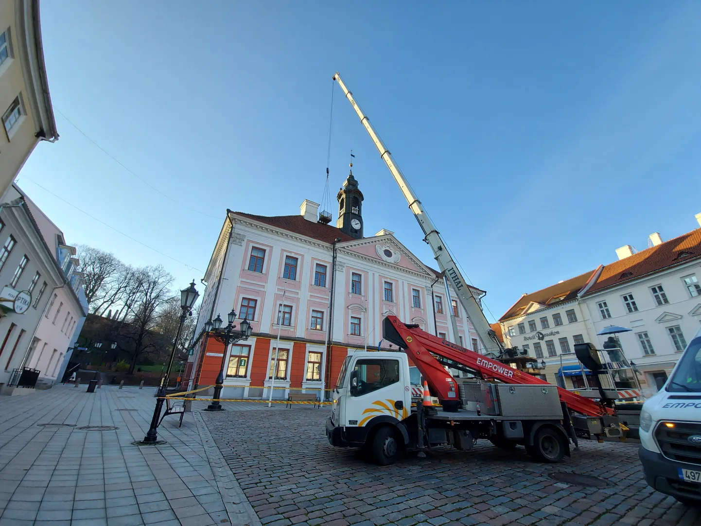 Kraana tõstis mehed ja materjali Tartu raekoja katusele.